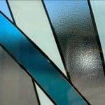 Frosted glass with geometric patterns, featuring blue and white diagonal stripes intersected by black outlines, enhanced with 3M decorative film for a modern aesthetic.