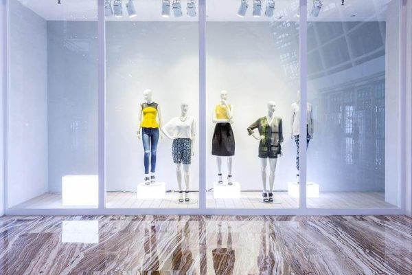 Mannequins in fashion shop display window.