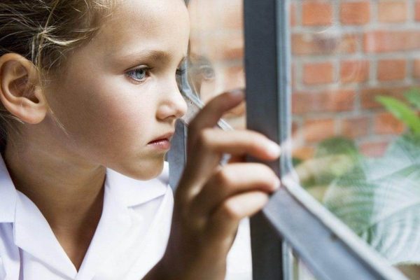 Child at a classroom window where school security window film adds protection