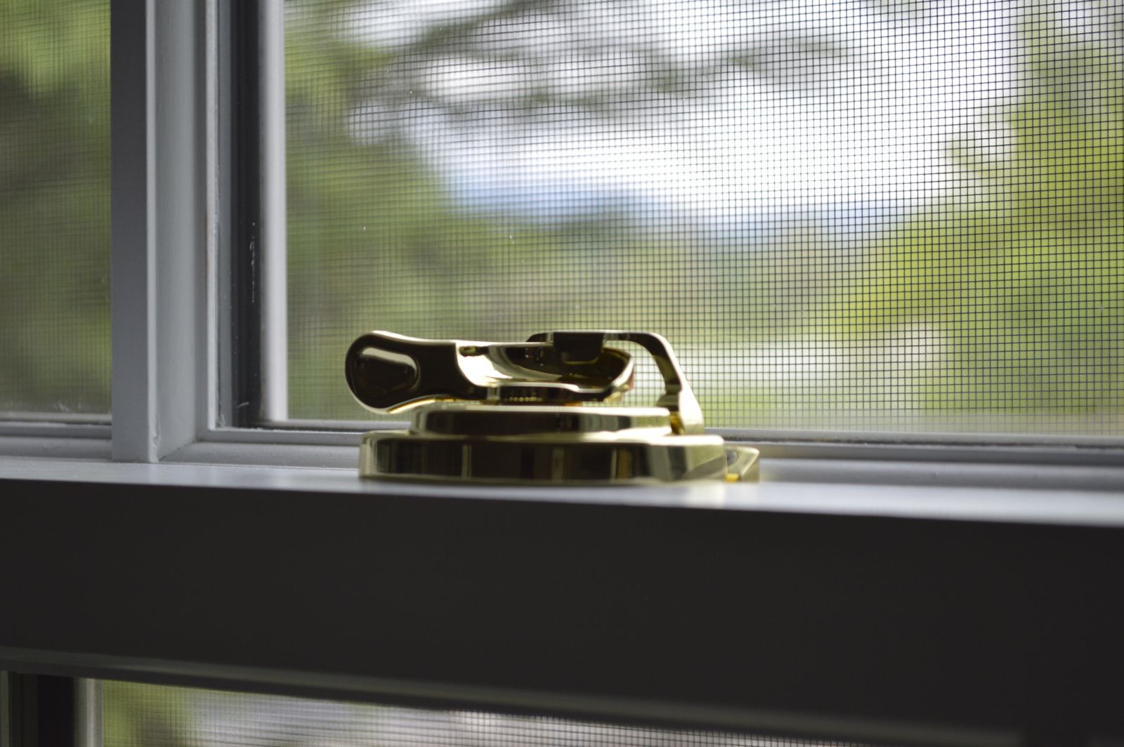 Burglar proof window film starts at the glass: brass sash lock on a home window