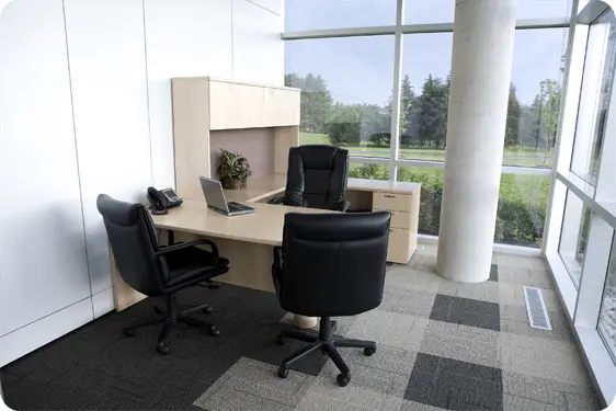 office desk with three black chairs in front of windows
