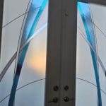 Double doors with frosted glass panels enhanced by 3M decorative film, featuring abstract blue and gray curved lines, with light shining through from behind.