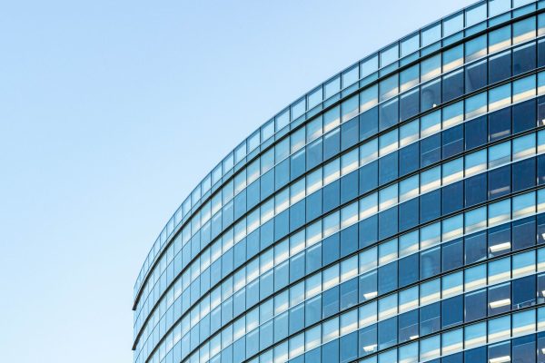 flat-glass-window-film-commercial-building Flat glass window film on a modern commercial building glass facade in the sun