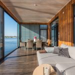 Florida waterfront living room with floor-to-ceiling glass facing bright afternoon sun