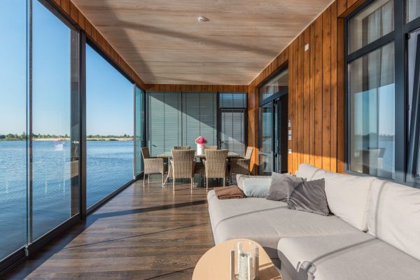 Florida waterfront living room with floor-to-ceiling glass facing bright afternoon sun
