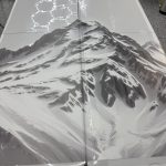 Two folding tables placed side by side, featuring a black and white mountain landscape printed across their surfaces with a sleek decorative film finish.