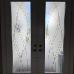 Frosted double glass doors with abstract linear patterns and silver handles, enhanced by 3M decorative film, letting in diffused natural light.