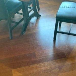 Two chairs on a less faded section of wooden floor.