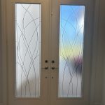 White double front doors with frosted glass panels feature an abstract line design enhanced by decorative film; the panels display a subtle gradient from blue to yellow outside.