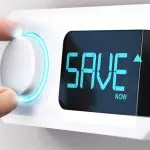 Hand turning the knob of a thermometer labeled, "SAVE NOW."