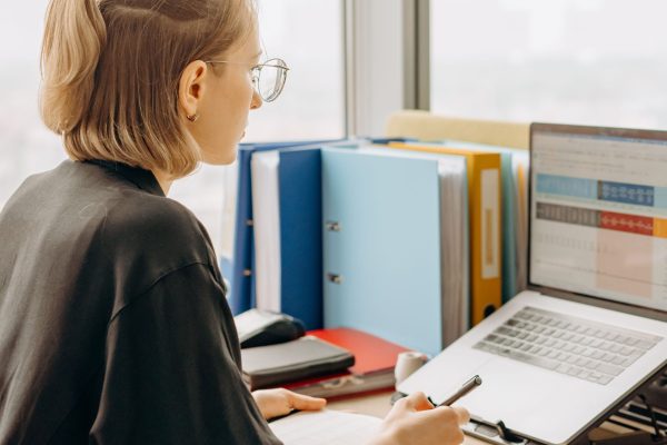 Employee battling afternoon glare and heat at a sunny office window before window film