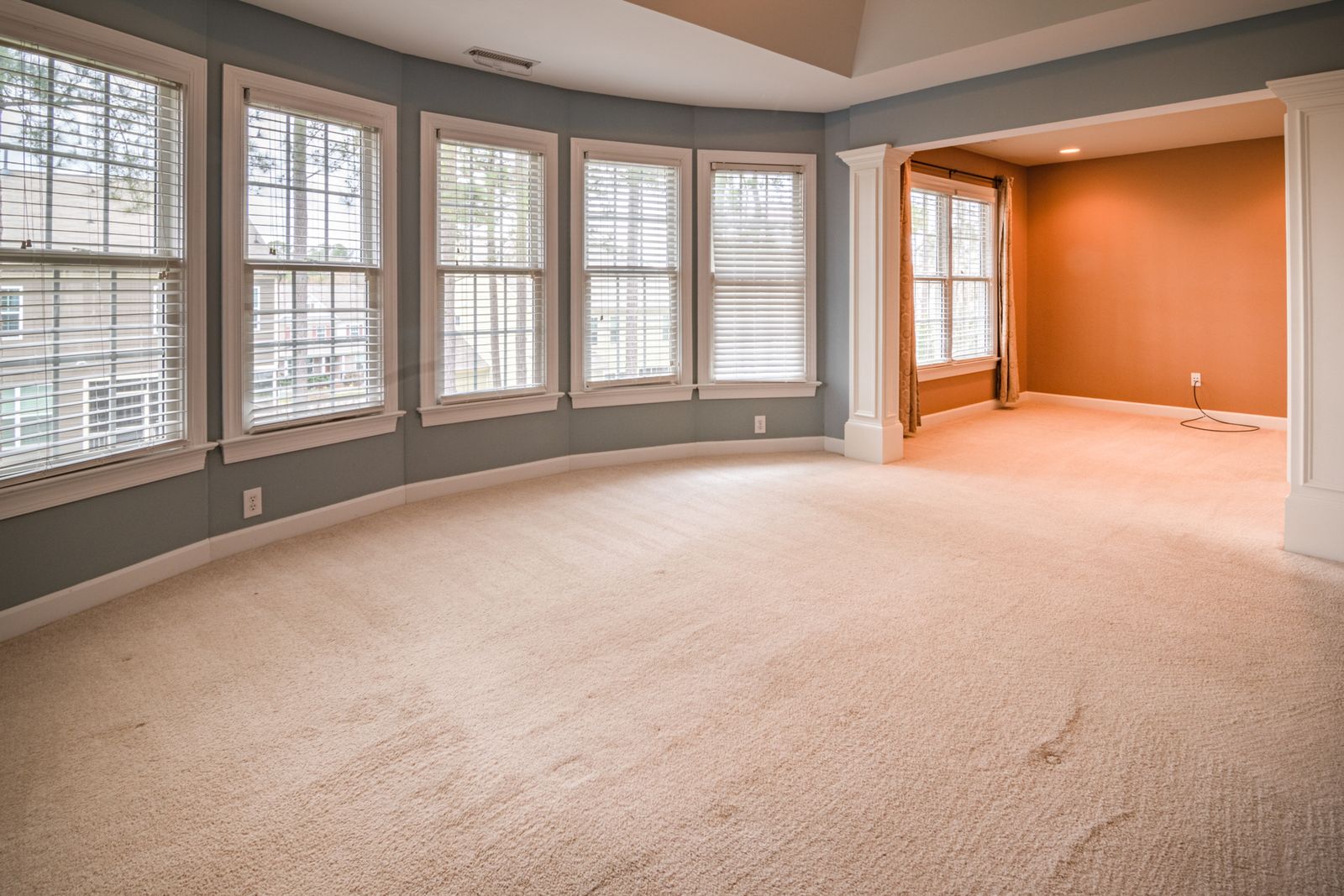 Room with a curved wall of windows where afternoon sun drives up indoor temperatures