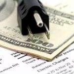 A U.S. one hundred dollar bill, electric plug, and utility bills are stacked together beside a roll of 3M window tint.