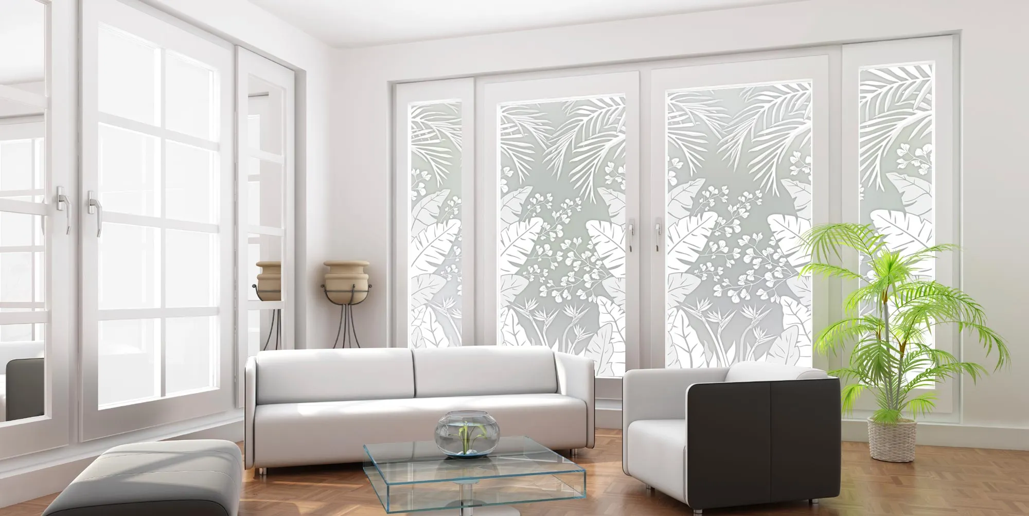 Modern living room with white furniture, a glass coffee table, potted plant, and large windows covered with decorative privacy film featuring a botanical pattern.